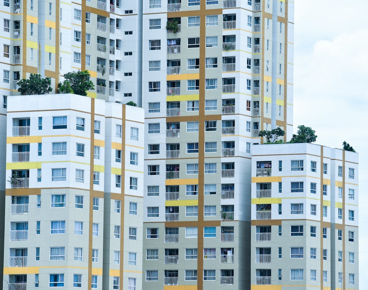 Giá Nhà Tăng 5–7% Nửa Cuối 2026: Giao Dịch Vẫn Chậm? 3 Khu căn hộ nhiều tòa với mảng xanh minh họa nguồn cung và thanh khoản