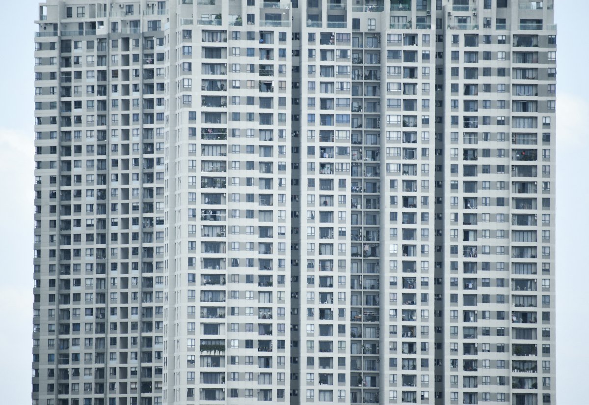 Giá Nhà Tăng 5–7% Nửa Cuối 2026: Giao Dịch Vẫn Chậm? 2 Khối chung cư cao tầng hiện đại minh họa mặt bằng giá nhà mới